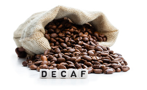 Roasted  coffee beans scattered out of the bag. Concept of decaf coffee 
