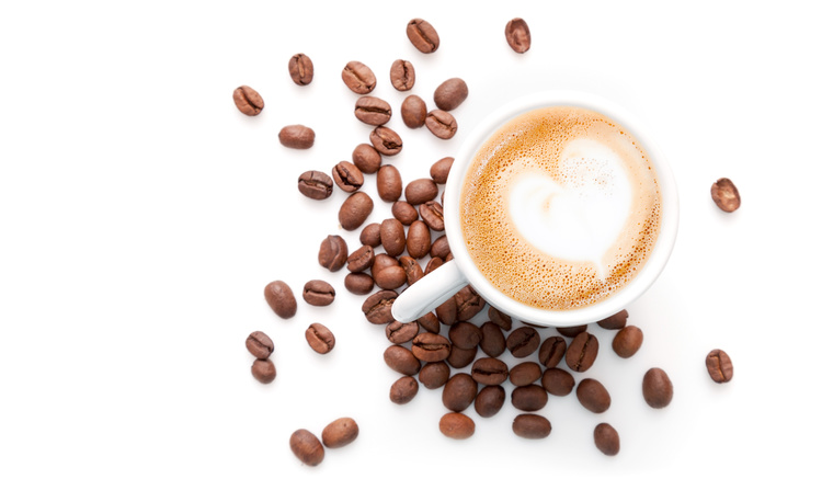 Small cup of cappuccino with coffee beans and heart shaped milk foam, top view isolated on white background