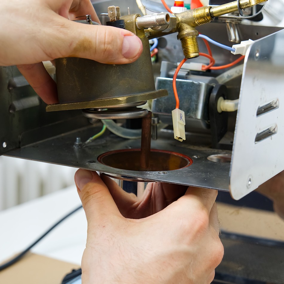 The master repairs the coffee machine. household appliances repair at home