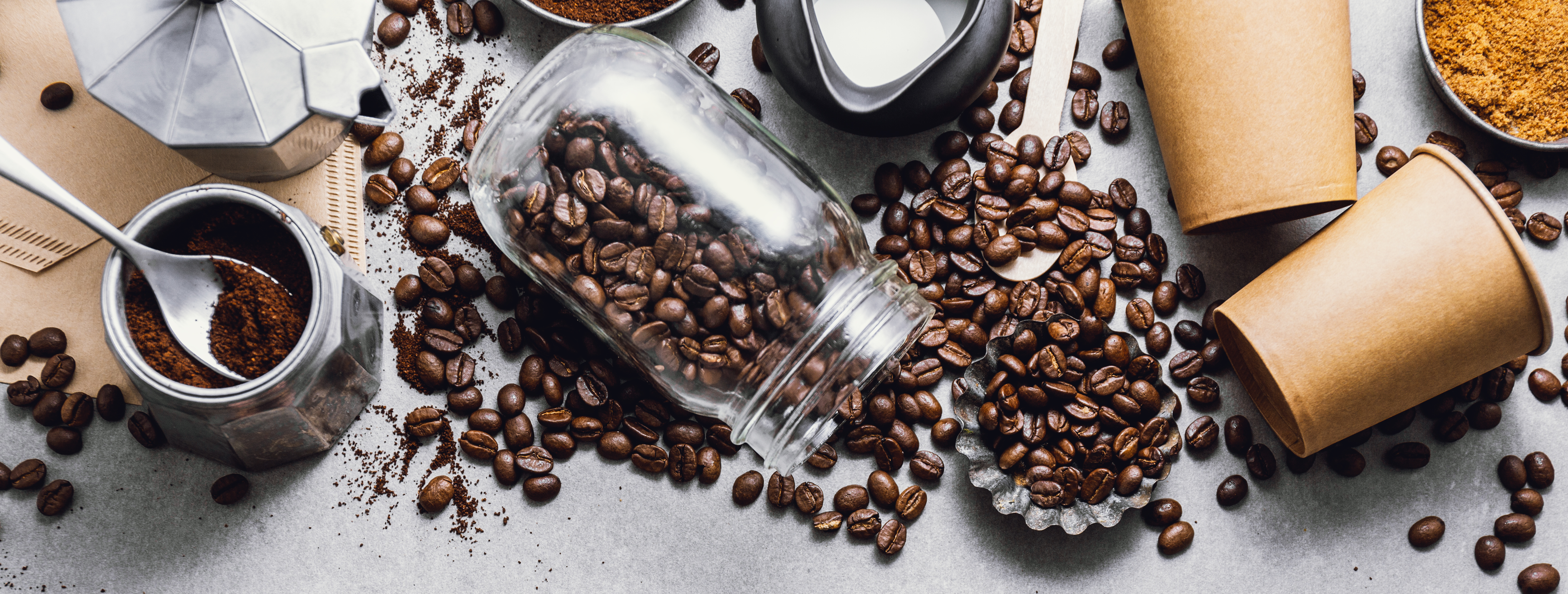 Ingredients for making moka coffee. Moka pot with coffee beans and ingredients on grey background. Coffee making concept. Flat Lay. Horizontal. 