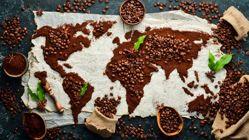Set of coffee beans and ground coffee in the shape of a world map. Top view. On a dark background.